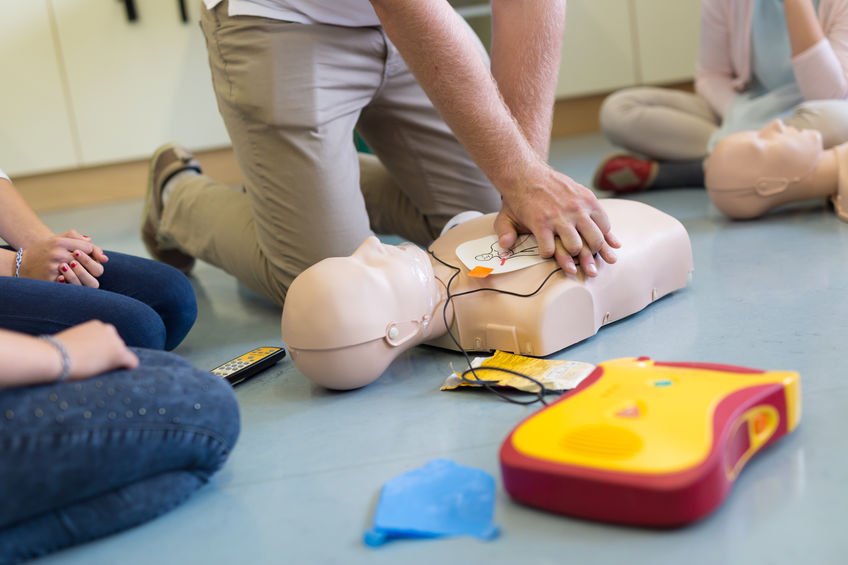 Student practicing CPR on dummy in class in Redlands, CA